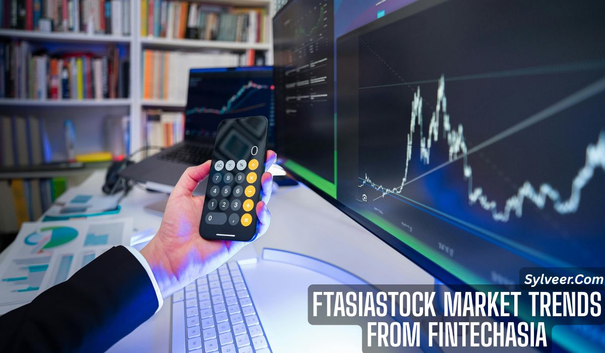 "Person analyzing stock market trends on multiple monitors while holding a smartphone with a calculator app open. Financial charts, graphs, and documents are visible on the desk. Text overlay reads: 'FTASIASTOCK MARKET TRENDS FROM FINTECHASIA - Sylveer.com'."