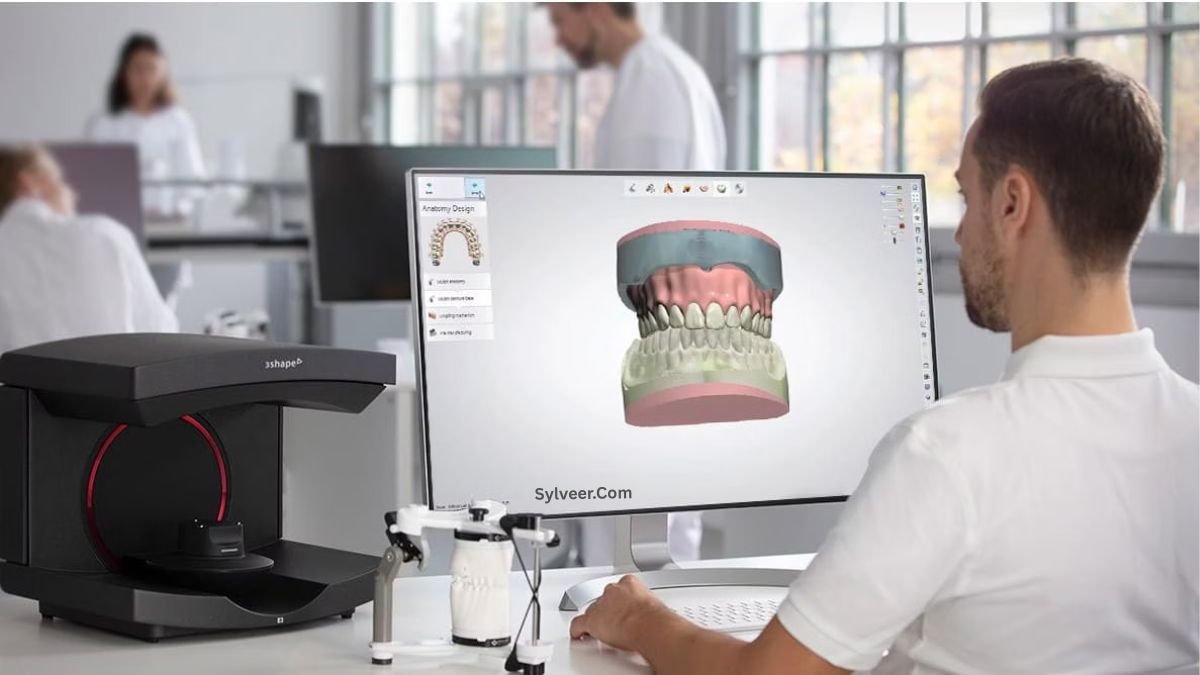 A CAD/CAM Tech works at a desk in a modern dental lab, viewing a detailed 3D digital model of teeth and gums on a large monitor. A 3Shape dental scanner and other dental equipment are placed beside him, showing a digital workflow for dental restoration design.